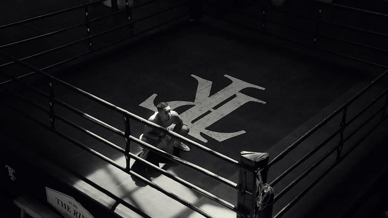 Vue plongeante du ring de The Ring à Bali, boxeur accroupi près des cordes, en noir et blanc